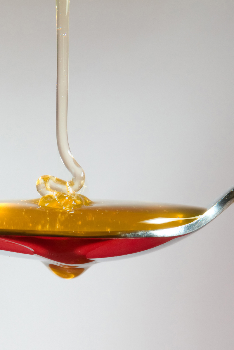 honey in a spoon on white background